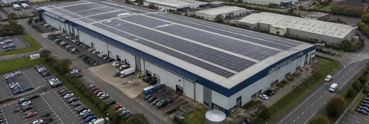 Solar panels installed on a UK commercial roof under overcast skies